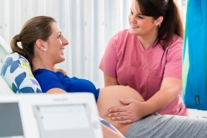 Midwife assisting a pregnant woman in the delivery room