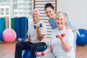 Elderly people using weights with a physical therapy professional