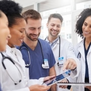 Group of medical professionals smiling and looking at a tablet