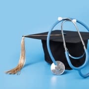 Graduation cap and a stethoscope against a light blue backdrop